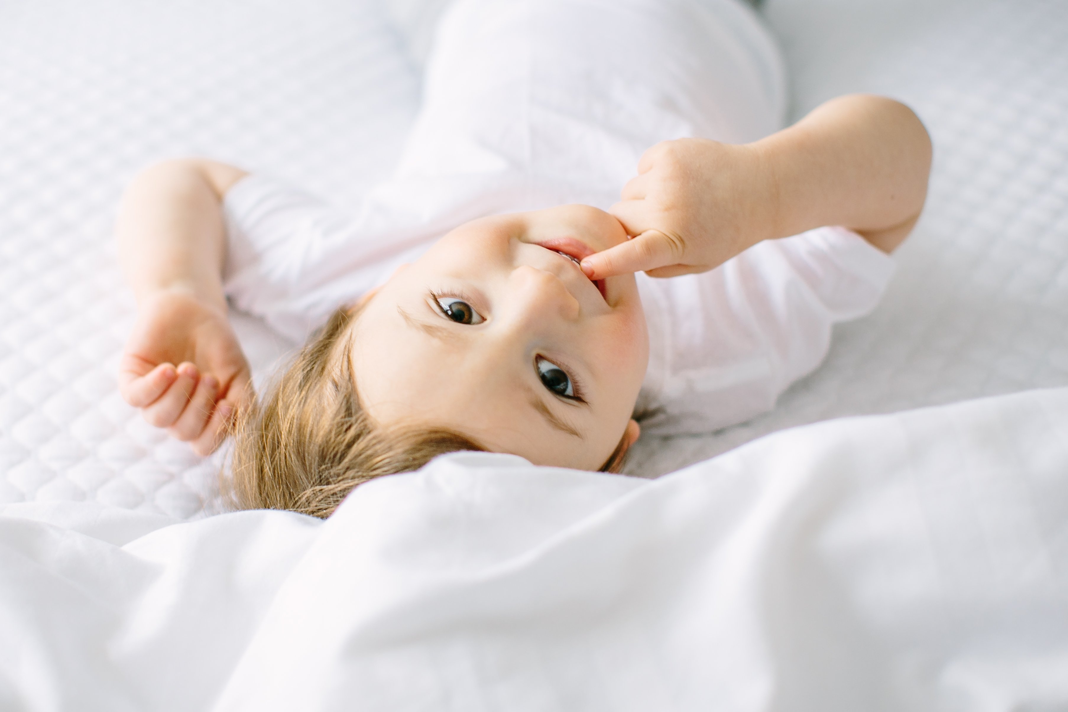 Maternity and Family Session, Fine Art Photography - Lauren Renee Photography toddler playing around on a white bed during family portrait session