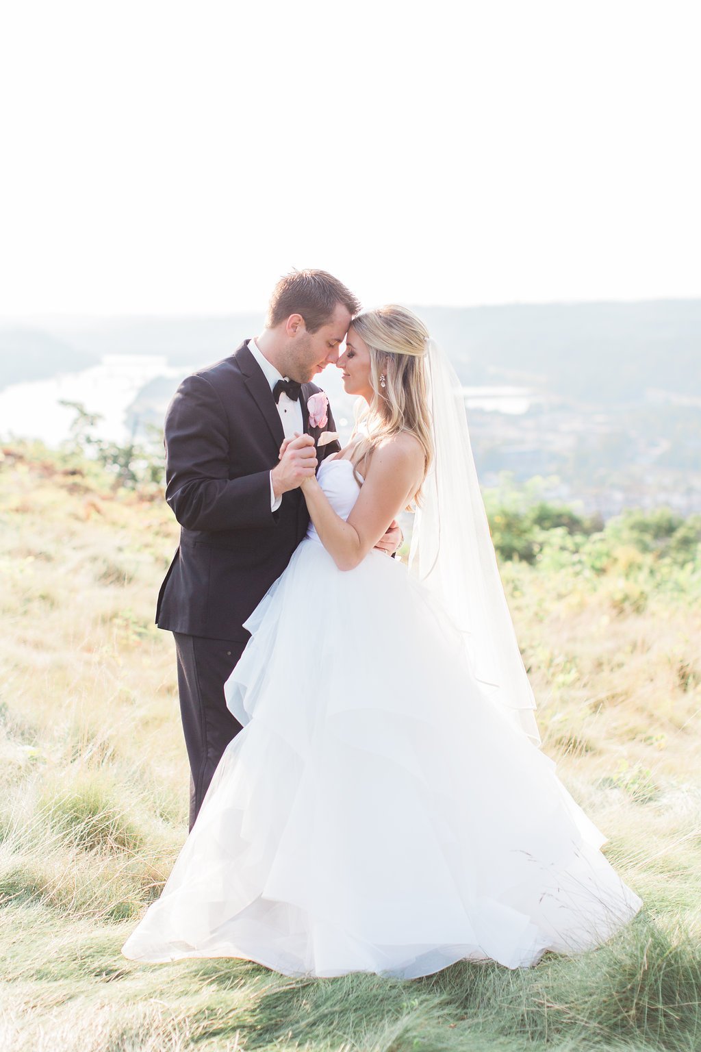 Lauren Renee Photography Bride and groom posing on a grassy hill