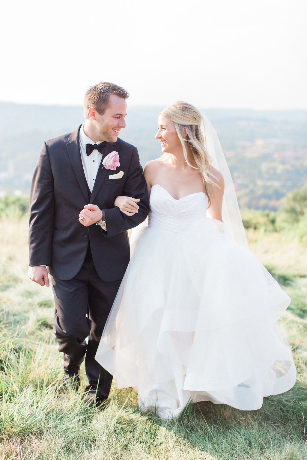 Lauren Renee Photography Bride and groom walking holding hands in a field