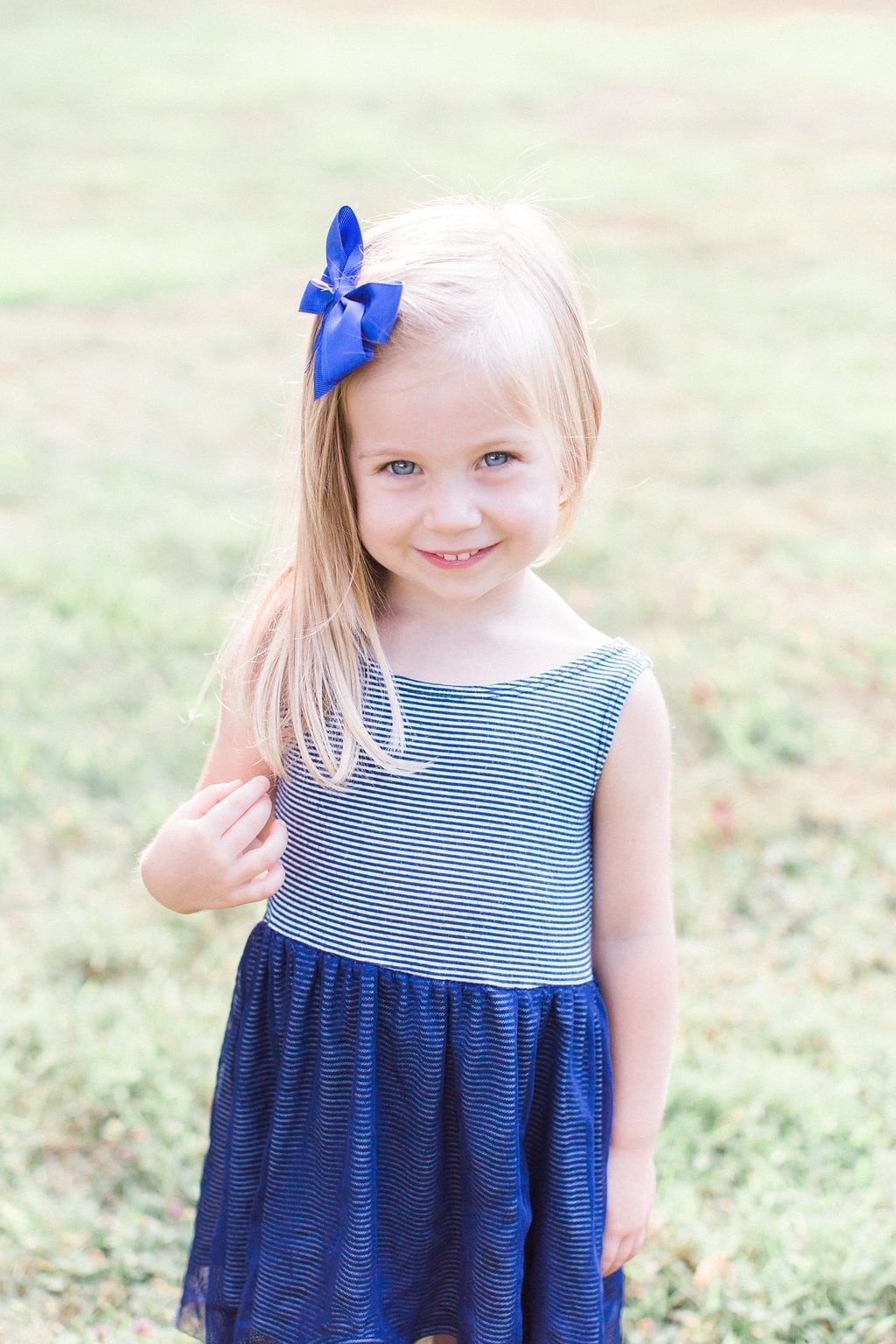Family - Lauren Renee Photography Little girl wearing blue bow and blue striped dress