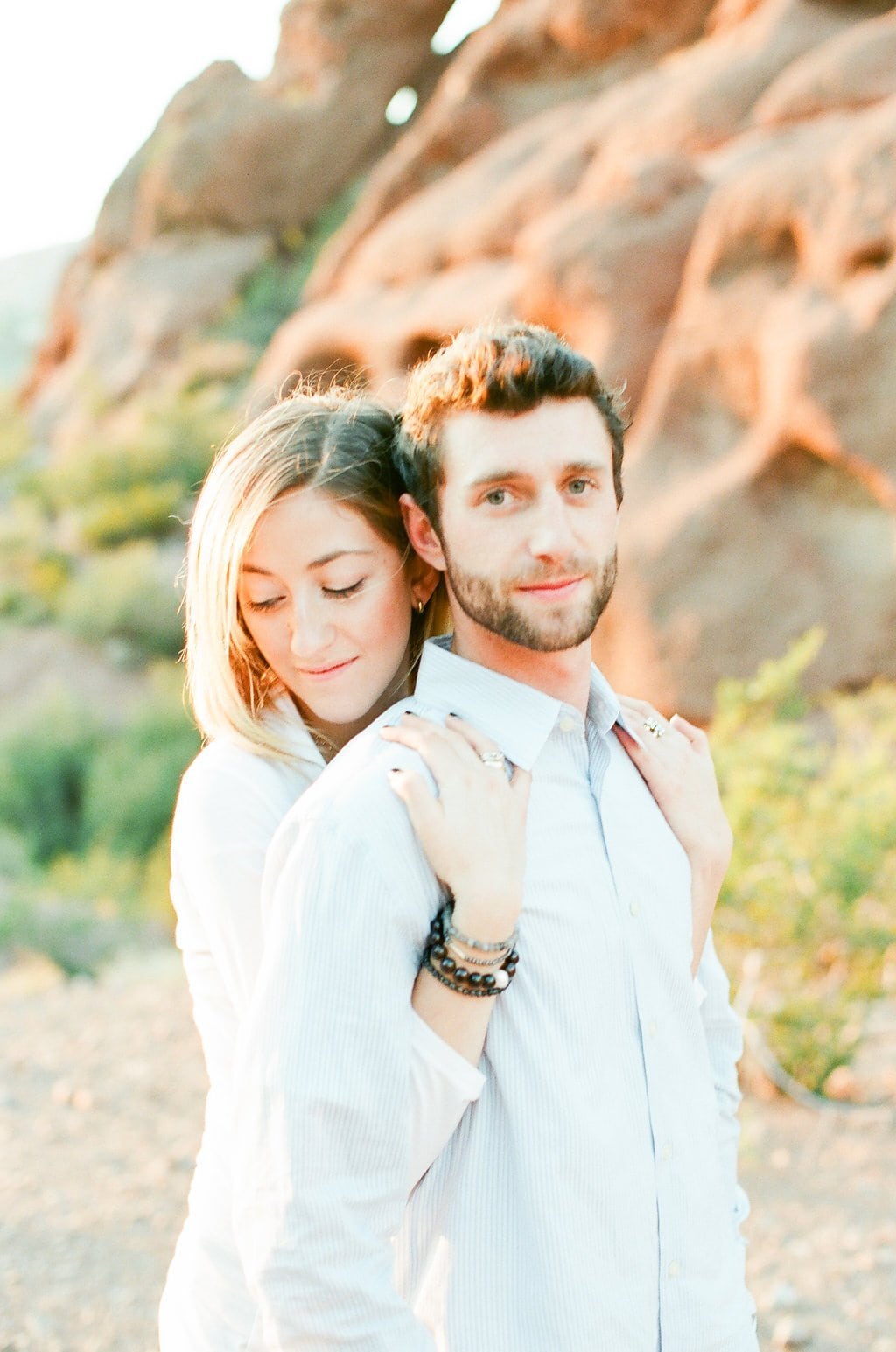 Shelby + Ethan, Arizona Engagement Photography, Travel and Destination Photography, Fine Art Photography, Film Photography - Lauren Renee Designs woman embracing man from behind grabbing his shoulders during engagement photos