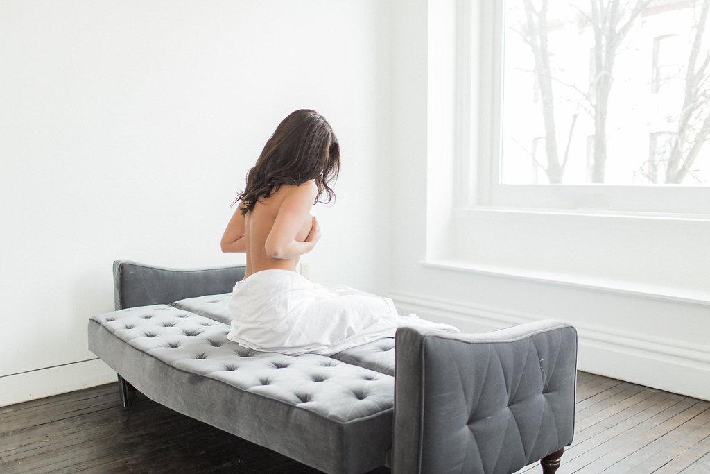 Lauren Renee Photography woman laying on grey velvet couch