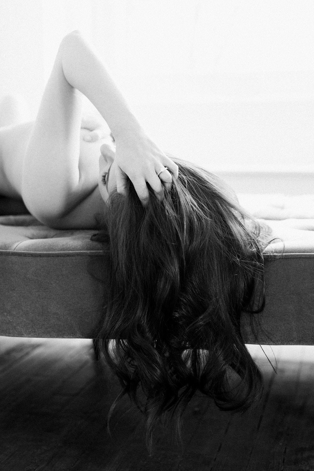 Lauren Renee Photography Black and white photo of woman laying on velvet couch