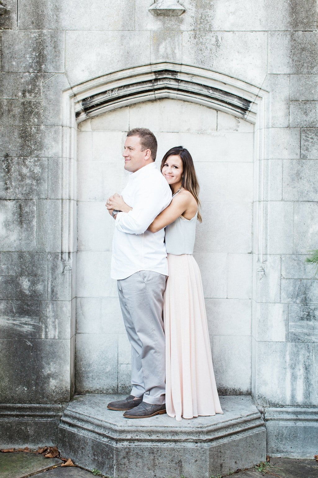 Lauren Renee - Pittsburgh Wedding Photography Bride cuddling up to her groom wrapping her arms around him while standing next to stone wall