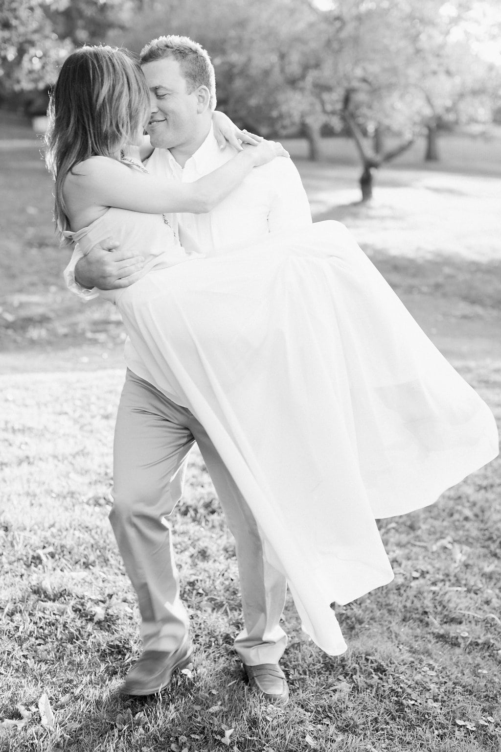 Lauren Renee - Pittsburgh Wedding Photography Black and white photo of groom carrying his bride across a field