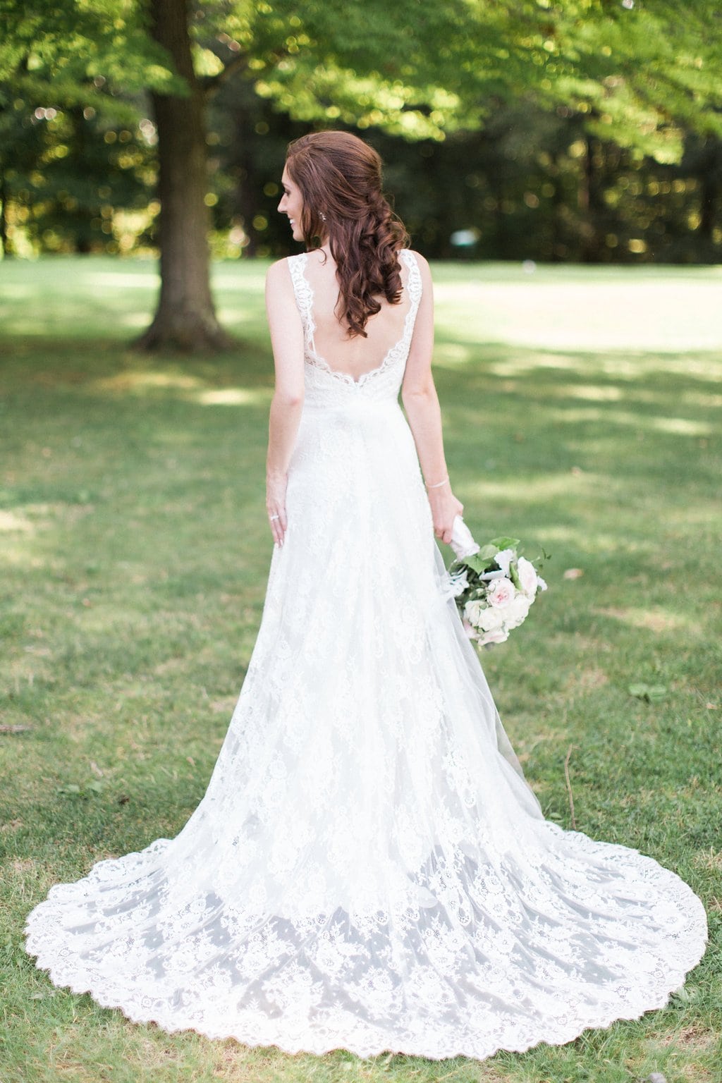 Golf Club Wedding - Lauren Renee Photography Bridal portrait of back of wedding dress with woman holding bouquet
