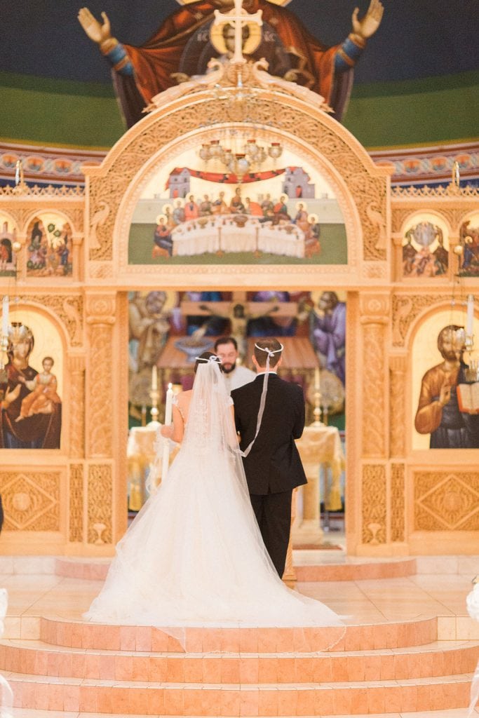 The bride and groom at the alter during their Greek wedding ceremony