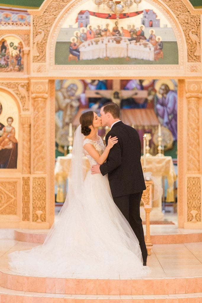 The couple's first kiss at the end of their wedding ceremony at the Greek Church