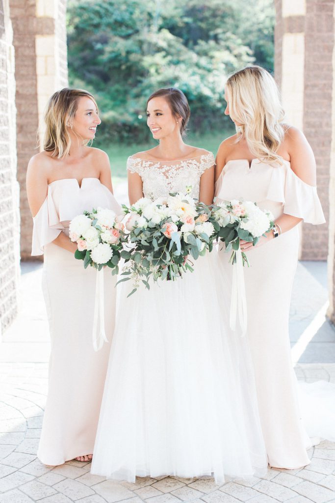 Bridesmaids wearing dresses from revolve clothing photos outside of church with bouquets