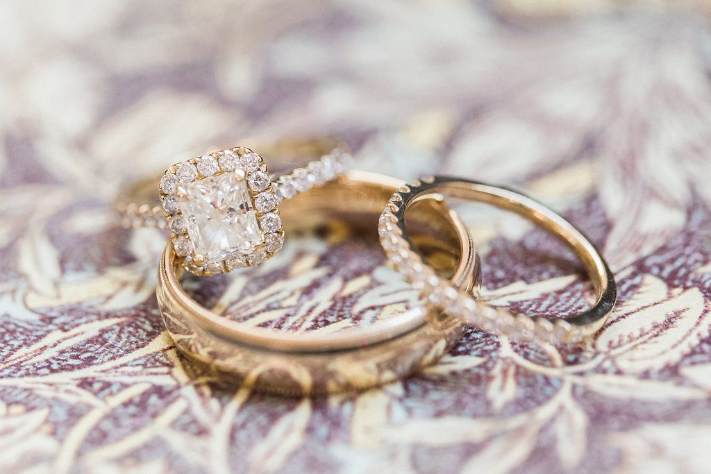 Wedding bands and engagement ring in yellow gold with diamond halo photograph