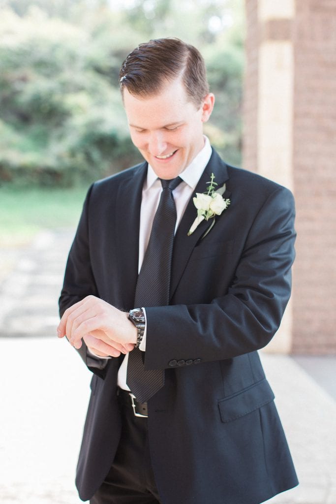 Groom getting ready fixing his cufflinks before the wedding