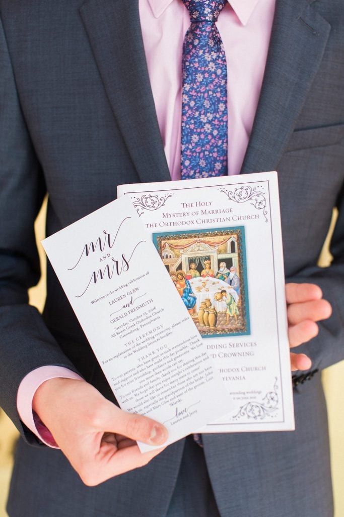 Wedding Programs held by a groomsman before the wedding ceremony