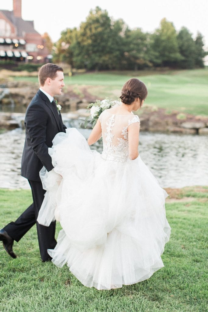 The bride and groom walking together during their portraits on the golf course at sunset