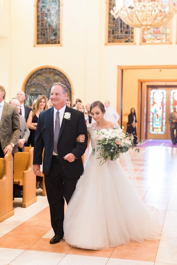 The bride walking down the isle with her father