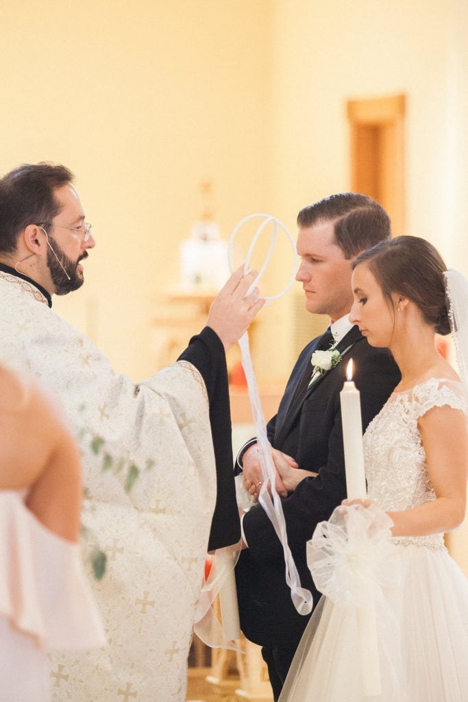 Greek Priest blessing the bride and groom during their wedding ceremony