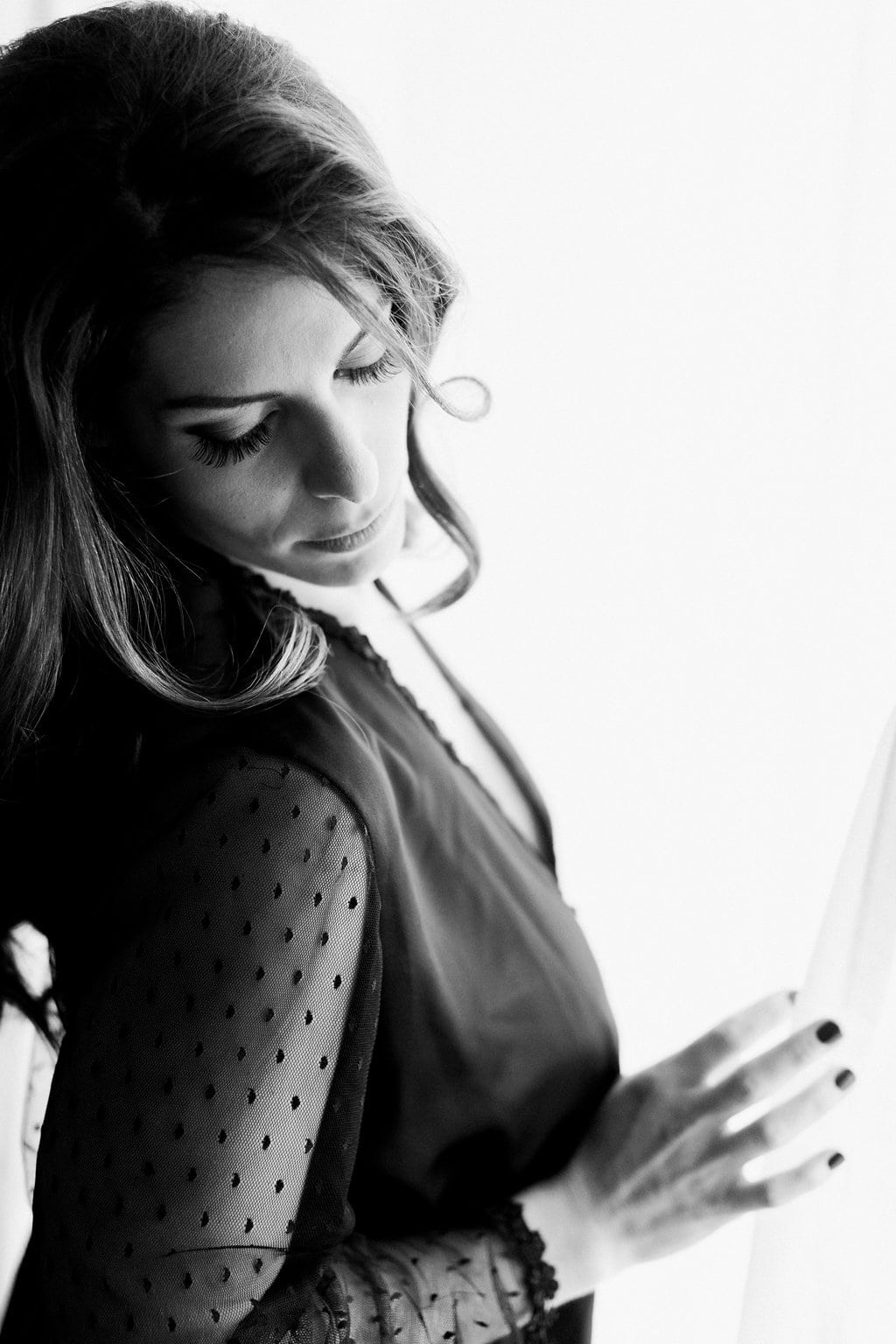 Lauren Renee Photography Black and white image of bride wearing a black robe near a window