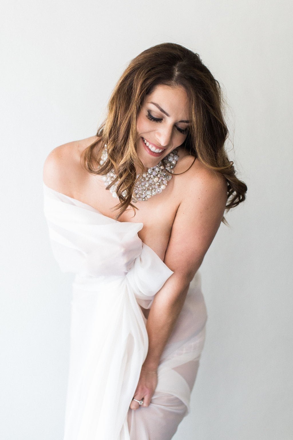 Fine art bridal boudoir in studio with model covered in white sheer fabric and laughing: Pittsburgh Boudoir Photography