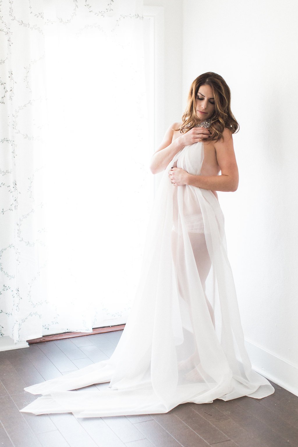 Lauren Renee Photography Woman in studio using sheer fabric to cover her naked body