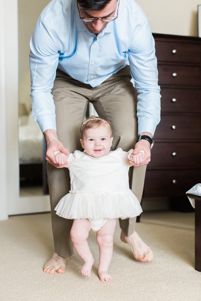 Father walking his baby daughter around the room