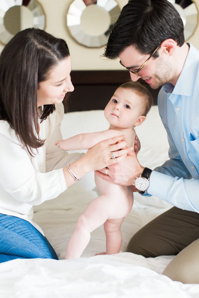 Mother and Father holding their naked baby during a in home family photo session