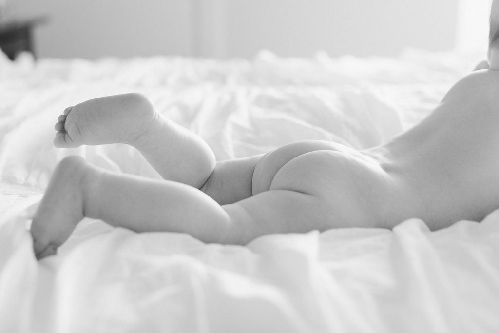 Photograph of baby's butt in black and white on bed