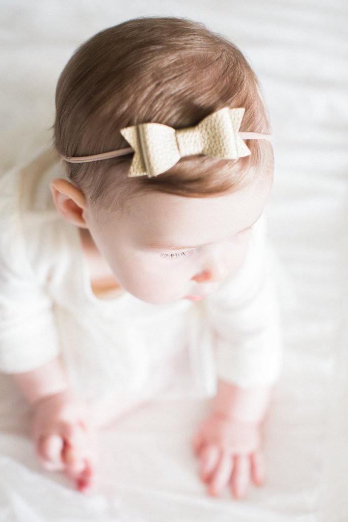 Photograph of a gold bow in baby's hair