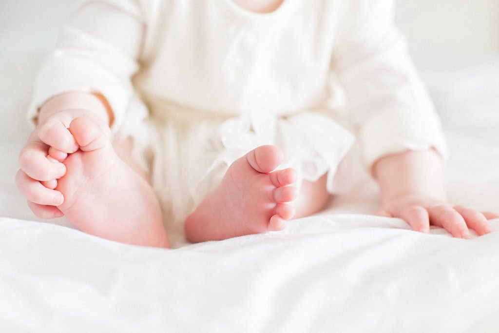 Baby grabbing at her toes during family photography session