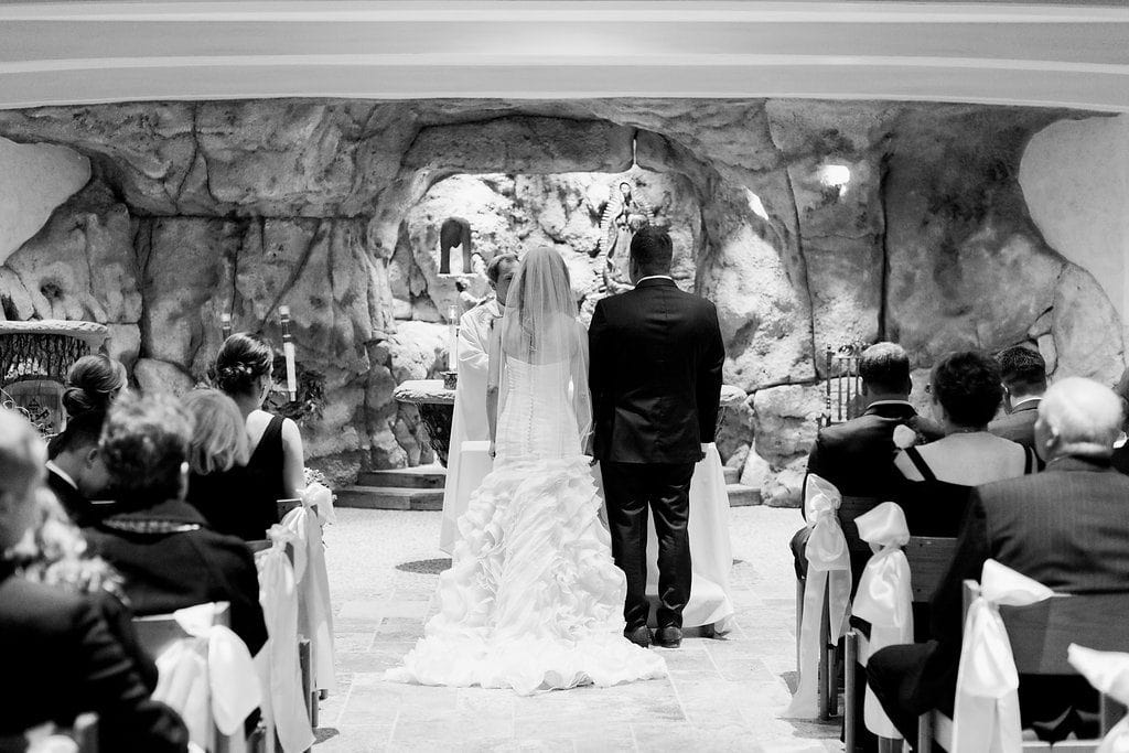 Black and white photograph of the bride and groom during their ceremony in the grotto