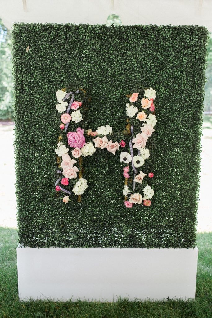 greenery wall with floral accents at bridal shower