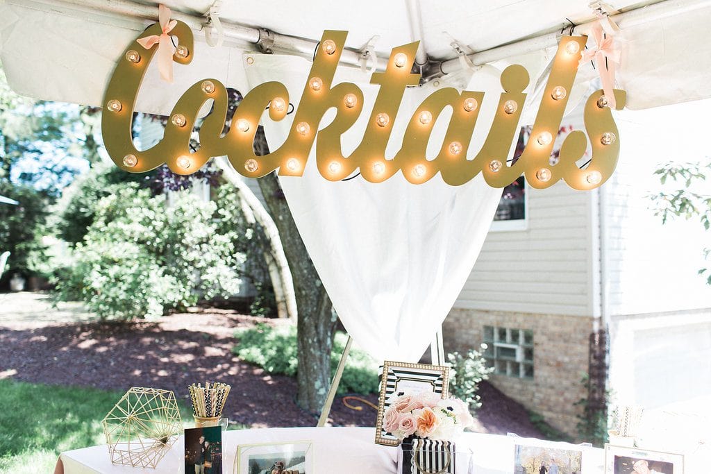 gold cocktail sign with lights at bridal shower