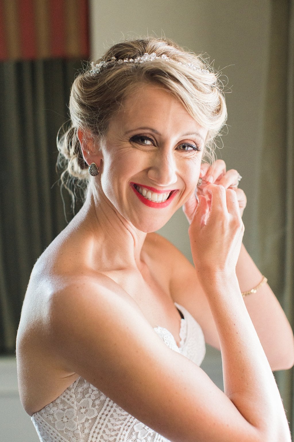 Bride is walked down the aisle by man who received her father's donated heart - Lauren Renee Photography Bride getting ready and putting earrings on at the Omni William Penn