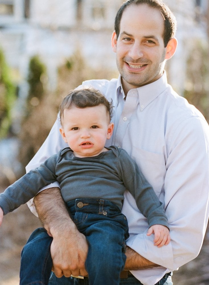 Dad holding baby outside during spring family session- Spring Family Portraits New Rochelle