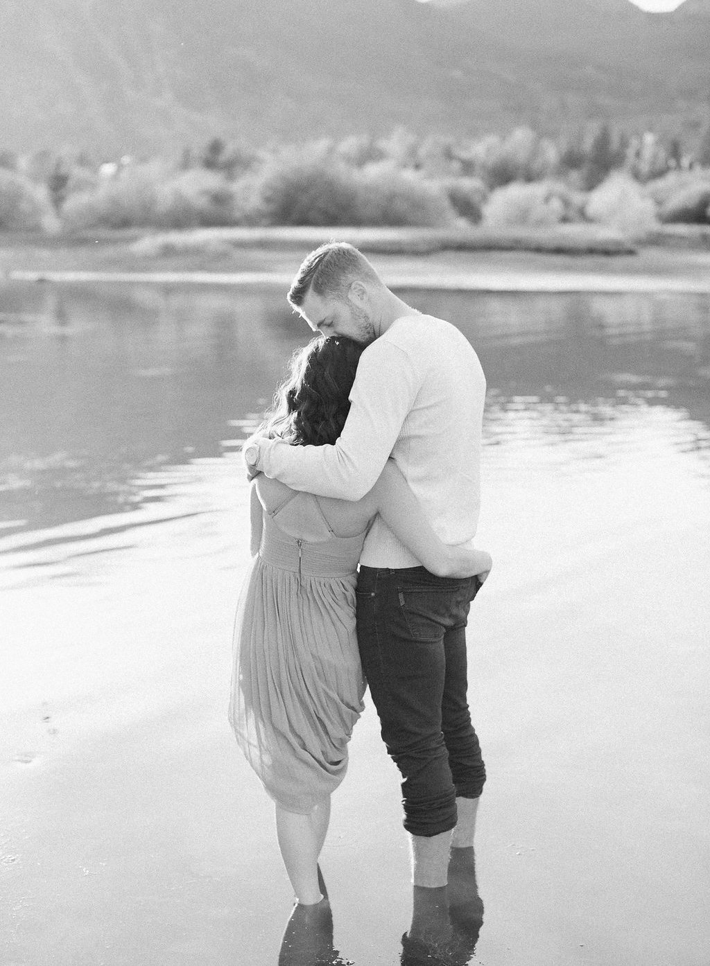 Destination Engagement Session - Lauren Renee Photography Bride and groom standing in lake kissing black and white