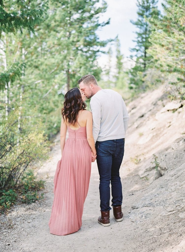 Lake Dillon Colorado Engagement Photography bride and groom walking in the trees kissing