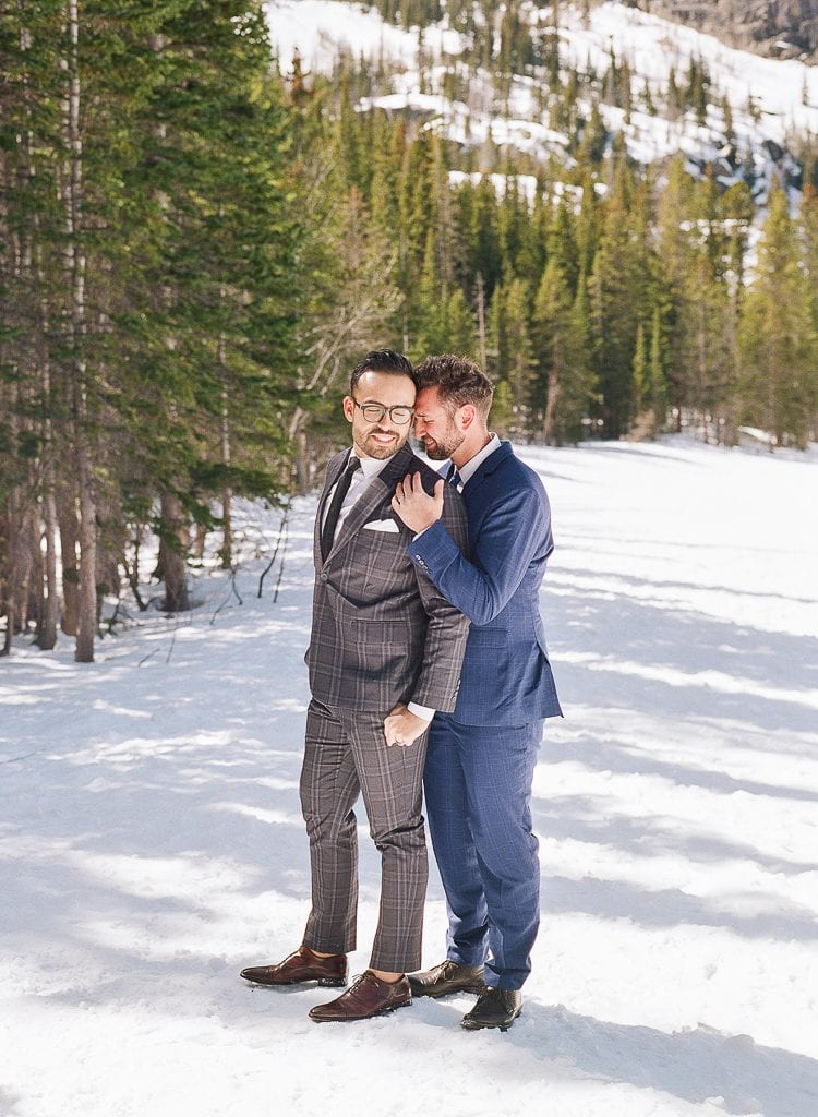 Estes Park Engagement Photography Session - two men embracing in the snow in the mountains in suits