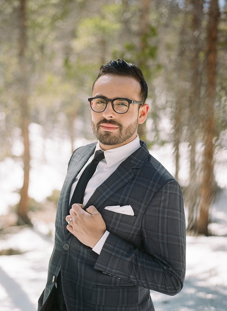 Sam-Sex Engagement Session - Lauren Renee Photography portrait of man with black glasses posing in a suit in the snow