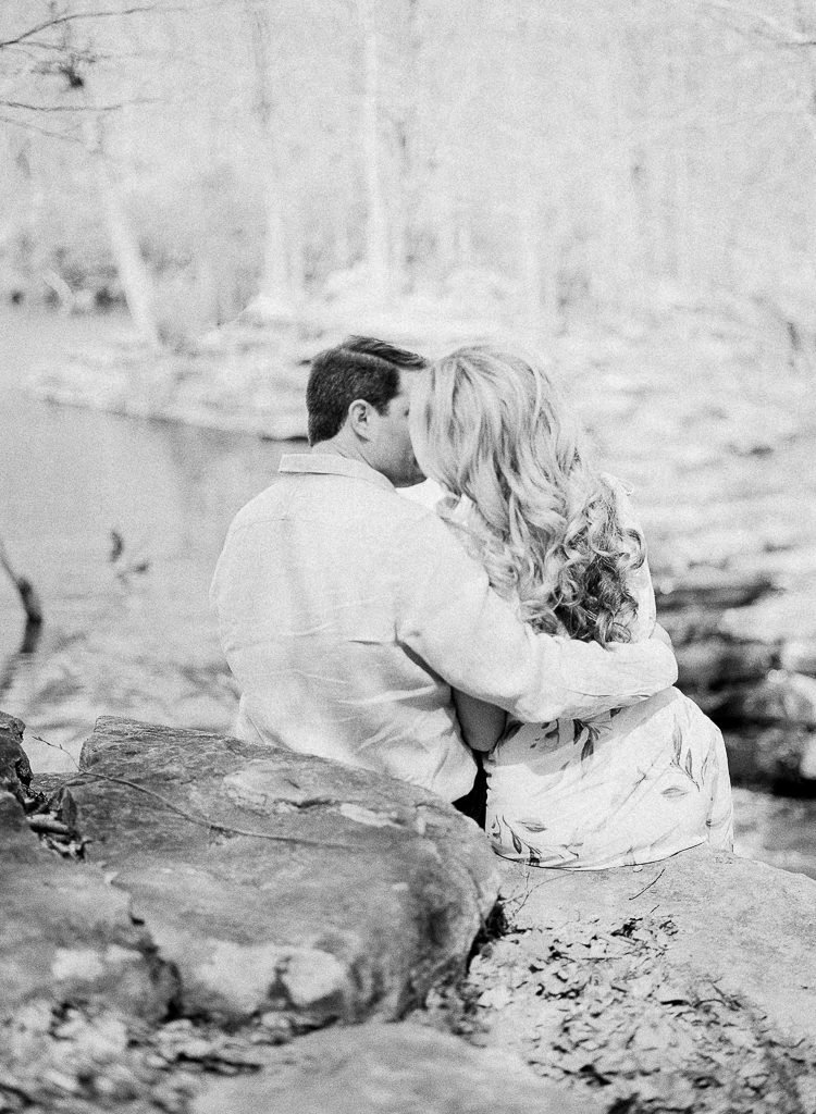 Seven Springs Engagement Photography - black and white photo of bride and groom kissing over a waterfall