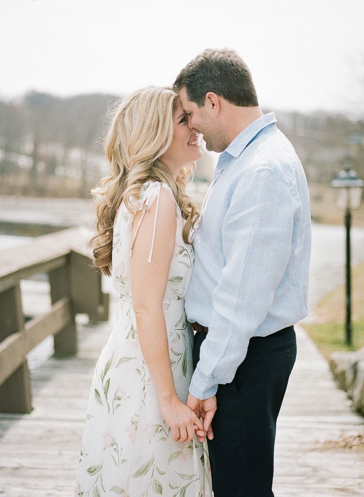 Seven Springs Engagement Photography - bride and groom snuggling and holding hands on a dock