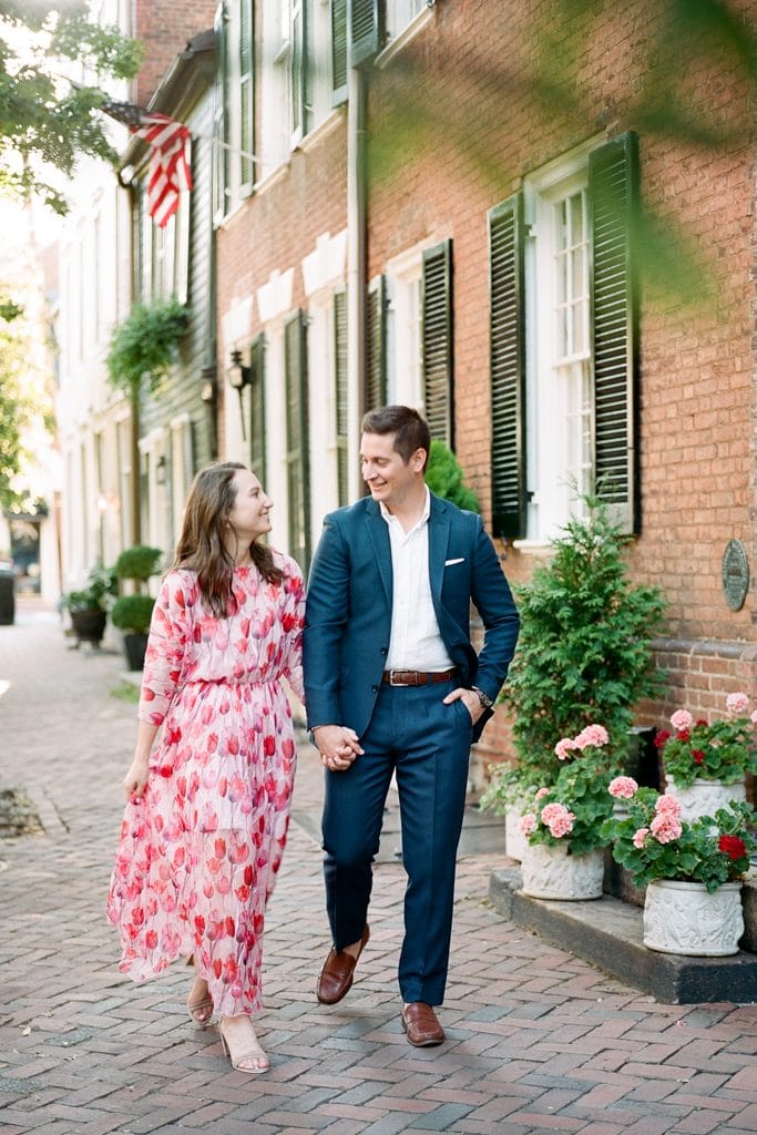 couple walking down the street holding hands in Old Town Alexandria Virginia during engagement session