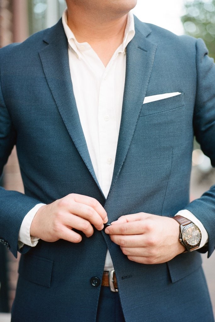 Engagement Session - Lauren Renee Photography groom buttoning up his blue suit during engagement photos
