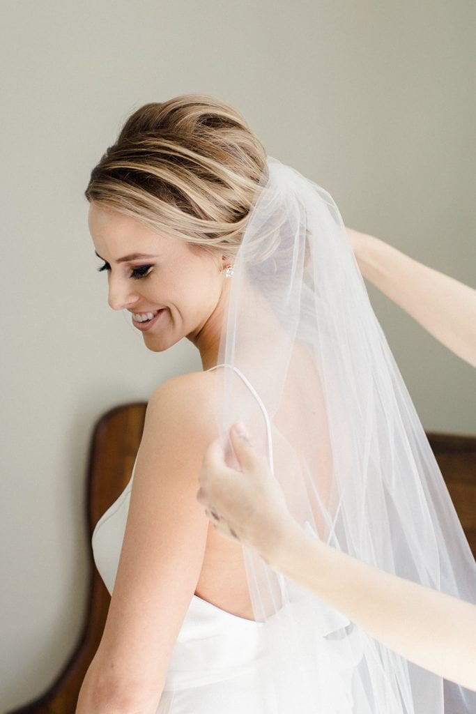 The Pennsylvanian Wedding Bride getting veil put on hair and makeup beauty justified by Justine Lynn