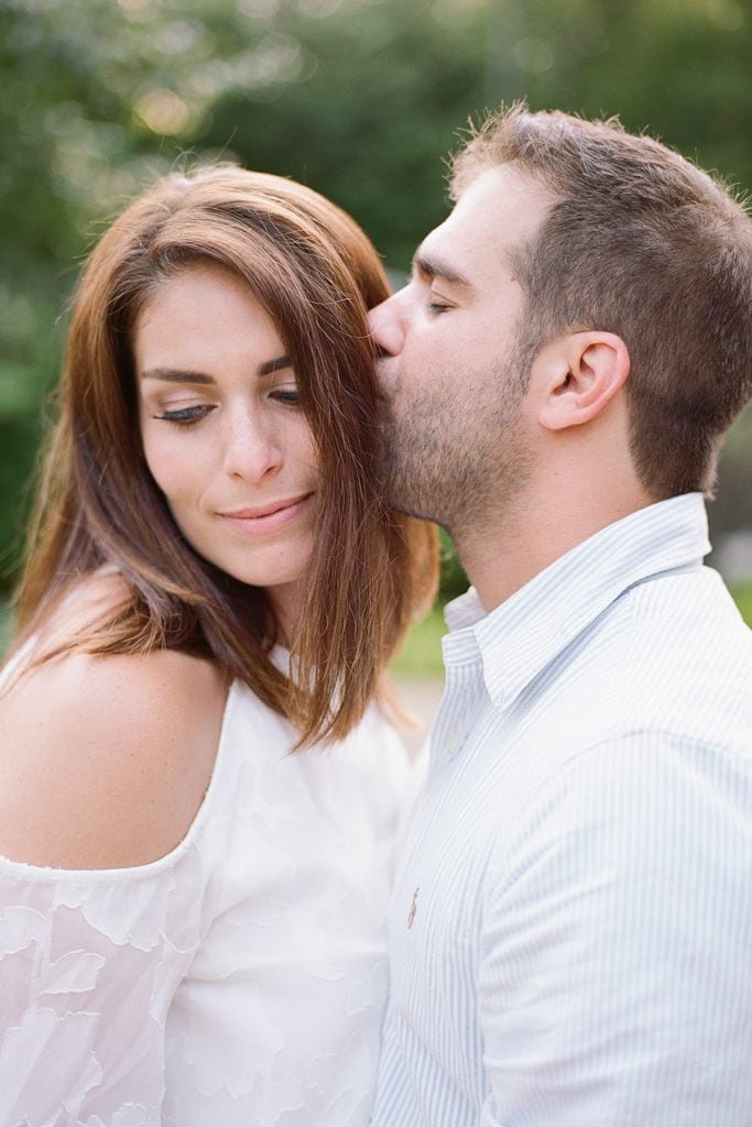 Dad kissing mom on the head during portrait session