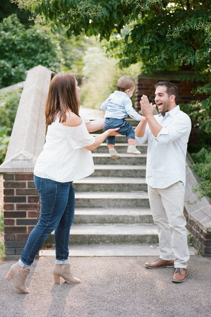 Mom and Dad swinging and playing with baby during Family Session at The Walled Garden