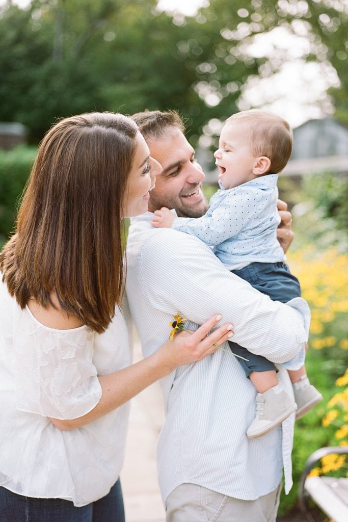 Family laughing together during portraits at the walled garden at mellon park