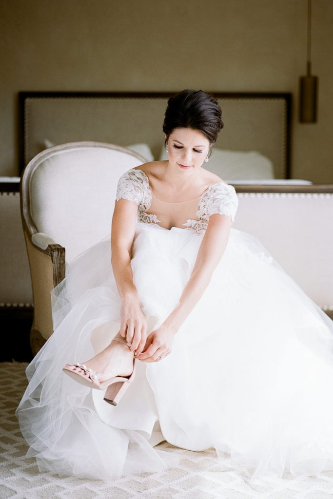 Beautiful bride putting on her wedding shoes