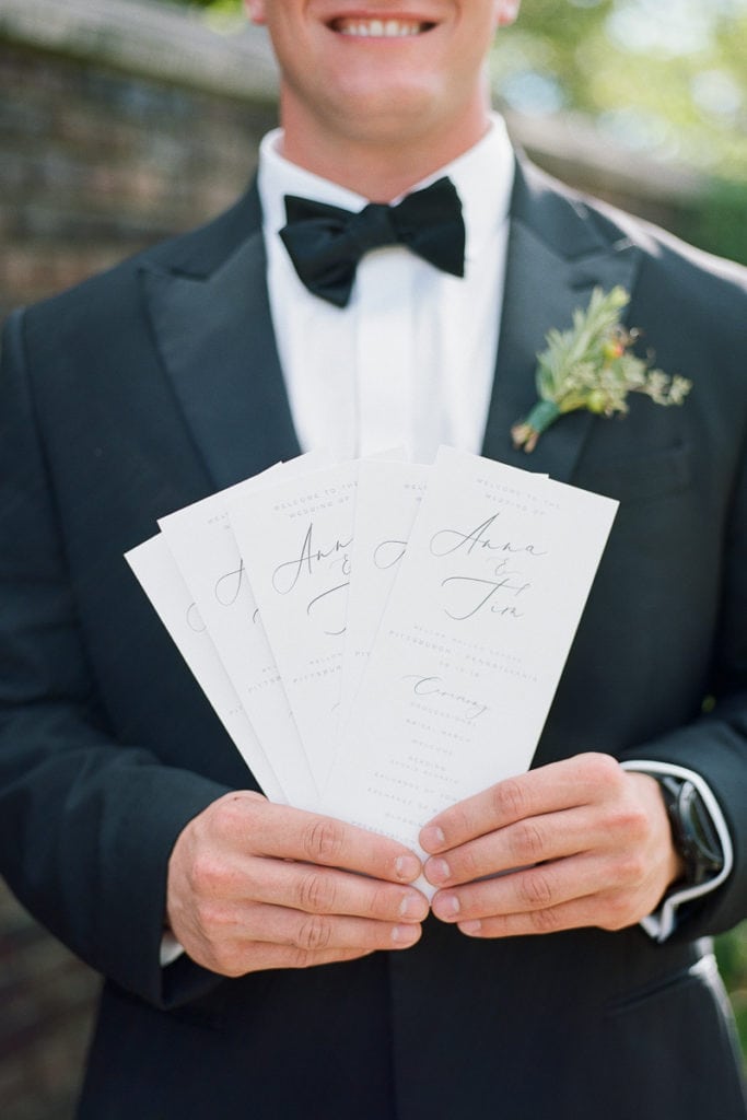 Ceremony programs held by a groomsmen