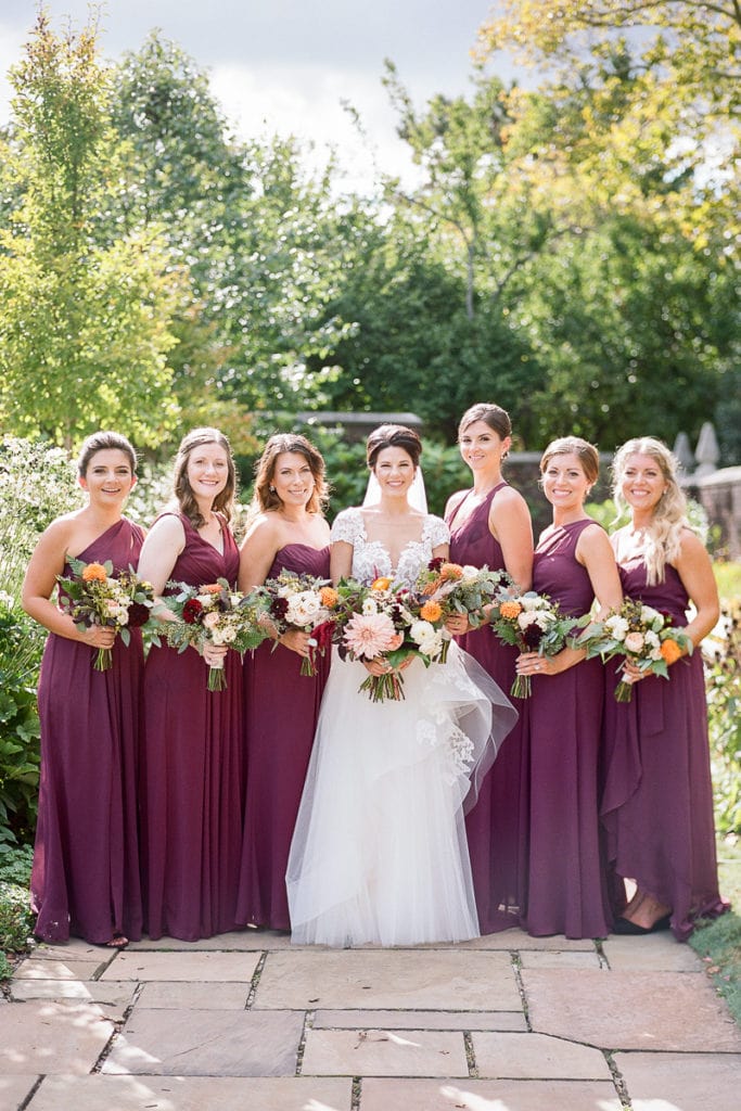 Bridesmaids dressed in plum purple dresses for fall wedding