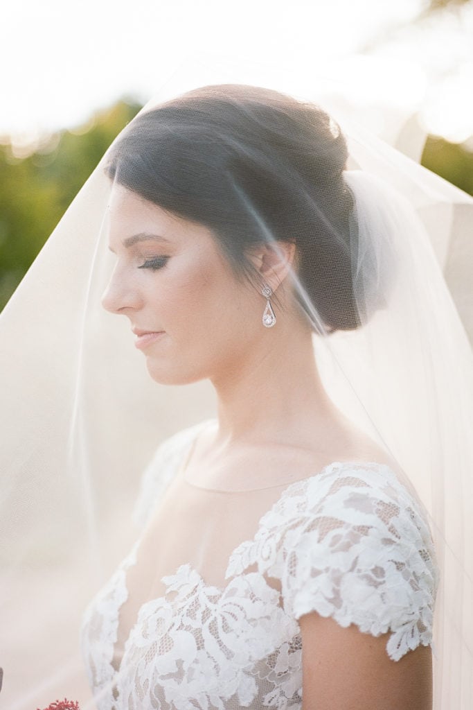 Bride under her veil with the sun shining through