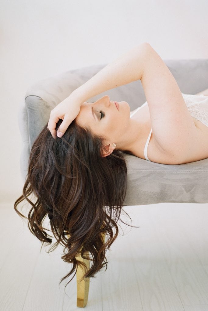 elegant bridal boudoir profile of a woman laying on a gray couch: Pittsburgh Boudoir Photography