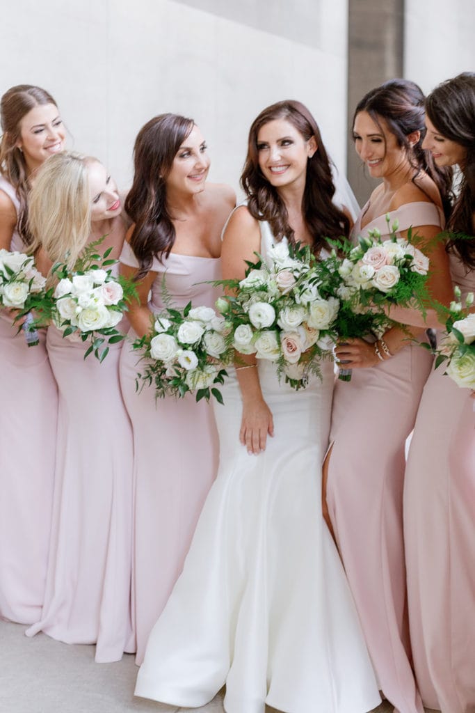 Bridesmaids in light pink dresses at the mellon institute columns